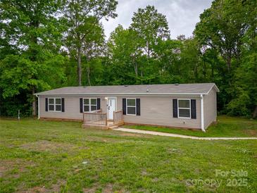 Charming single-story home with black shutters, covered front porch, and surrounded by lush greenery at 105 Peridot Dr, Statesville, NC 28625