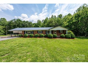 Charming single story home featuring a classic brick exterior and well-manicured lawn and landscape at 1094 Curve View Rd, Lincolnton, NC 28092