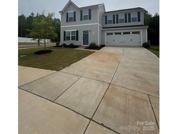 Charming two-story home featuring a well-manicured lawn and a two-car garage at 110 Browband St, Troutman, NC 28166