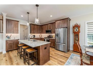Stylish kitchen features an island with a granite countertop, modern stainless steel appliances, and wooden cabinets at 1109 Bunch Dr, Statesville, NC 28677