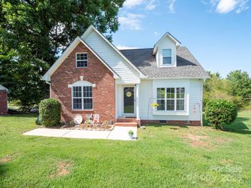 Charming brick and vinyl home featuring a manicured lawn and inviting front porch at 1918 Gables Dr, Monroe, NC 28112