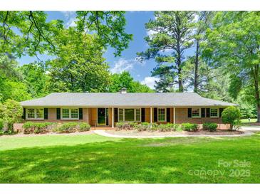 Charming brick home with lush green lawn and mature trees providing ample shade at 2001 Lakeview Dr, Pineville, NC 28134