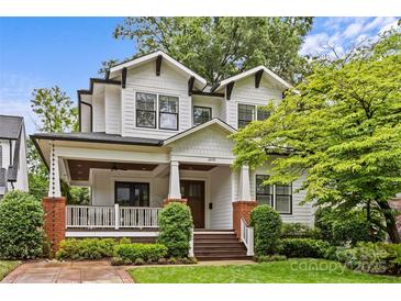 Charming two-story home featuring white siding, black trim, covered porch, and well-manicured landscaping at 2615 Chesterfield Ave, Charlotte, NC 28205