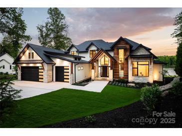 Stunning modern home featuring a beautiful blend of wood and stone accents and a well manicured lawn at 301 Riverwood Rd, Mooresville, NC 28117