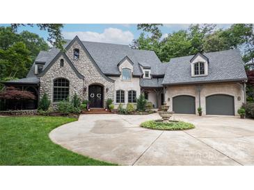 Charming stone home featuring a circular driveway and landscaped front yard with beautiful water fountain at 5523 Meadow Haven Ln, Charlotte, NC 28270