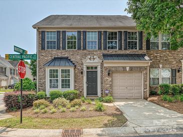 Charming brick townhome features a well-manicured front yard and an attached one car garage at 6505 Central Pacific Ave, Charlotte, NC 28210