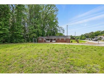 Single story brick home with a large front lawn and mature trees offering lots of privacy at 800 Old Little Rock Rd, Charlotte, NC 28214