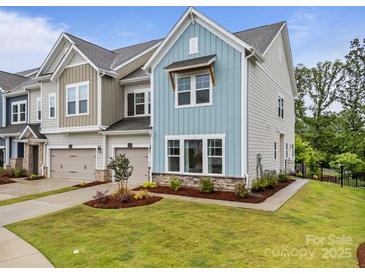 Charming townhome showcasing craftsman-style architecture, a 2-car garage, and a landscaped yard at 8215 Houser St, Cornelius, NC 28031