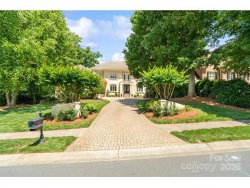 Charming home featuring a brick driveway surrounded by lush greenery and mature trees at 14515 Nolen Ln, Charlotte, NC 28277