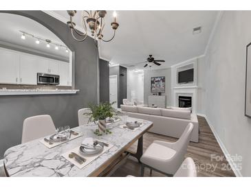 Bright and airy living room featuring a marble dining table, white sofa, fireplace, and a seamless flow to the kitchen at 1915 Travertine Ln, Fort Mill, SC 29708