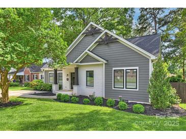 Charming home featuring a modern exterior with gray siding, a white brick porch, and meticulously landscaped front yard at 3163 Maury St, Charlotte, NC 28208
