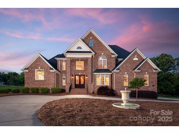 Stately two-story brick home with manicured landscaping and a circular driveway with fountain at 534 N Ingleside Farm Rd, Iron Station, NC 28080