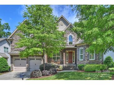 Beautiful stone-faced two-story home with a well-manicured lawn and attached two-car garage at 7428 Edenbridge Ln, Charlotte, NC 28226