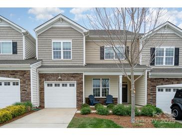 Charming townhome with stone accents, attached garage, and cozy front porch with chairs at 829 River Park Rd, Belmont, NC 28012