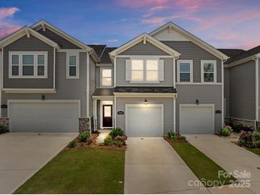 Charming townhome featuring a one-car garage, inviting facade, and well-maintained landscaping at 5625 Axil Ln, Charlotte, NC 28269