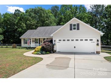 Charming ranch home with a two-car garage, well-manicured lawn, and a sidewalk leading to the front door at 5764 Grassy Creek Rd, Denver, NC 28037