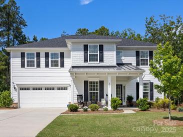 Charming two-story home featuring a white exterior, black shutters and a well-manicured front yard at 603 Southstone Dr, Matthews, NC 28104