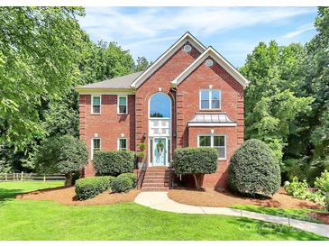 Charming two-story brick home with manicured lawn and mature trees at 655 Powder Horn Ln, Indian Trail, NC 28079