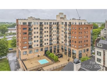 A multi-story building features brick and stucco accents, balconies, a pool, and modern outdoor art at 715 N Church St # 613, Charlotte, NC 28202