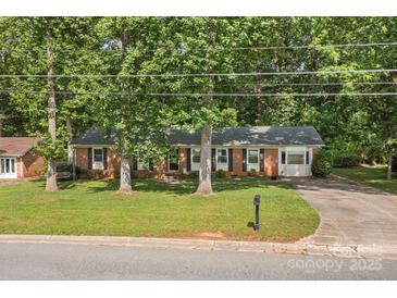 Charming brick home with mature trees, well-maintained lawn, and an inviting curb appeal at 844 Fieldstone Rd, Mooresville, NC 28115
