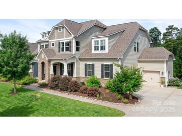 Charming two-story home with landscaped yard, stone accents, and welcoming front porch at 10911 Skymont Dr, Huntersville, NC 28078