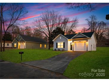 Charming single-Gathering home with green lawn and paved driveway at dusk at 1129 Thayer Glen Ct, Charlotte, NC 28213