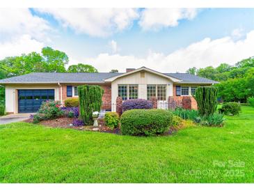 Charming one-story brick home with a well-manicured lawn, garden, and attached garage at 1184 Cambridge Dr, Shelby, NC 28152