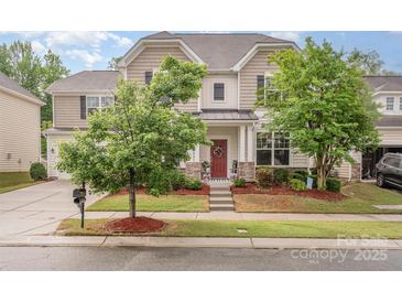 Charming two-story home with a red front door and mature landscaping at 12832 Heath Grove Dr, Huntersville, NC 28078