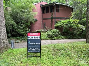 Charming home surrounded by lush greenery with a 'For Sale' sign out front at 1451 Blueberry Ln, Charlotte, NC 28226