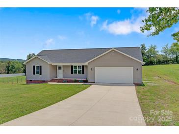 Charming single-story home with well-manicured lawn and a long driveway leading to an attached garage at 154 Stable Brook Ln, Taylorsville, NC 28681