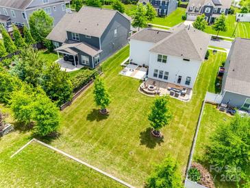 Expansive backyard featuring a fire pit, patio seating, and well-maintained green space, perfect for outdoor entertaining at 16008 Weeping Valley Dr, Fort Mill, SC 29715