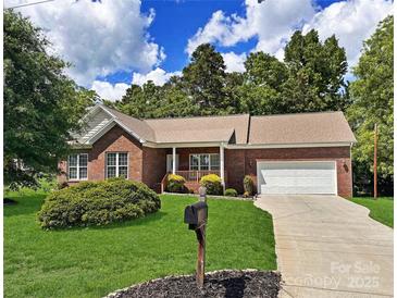 Charming brick home with a well-manicured lawn, mature trees, and an inviting front porch at 2016 Townview Dr, Kannapolis, NC 28081
