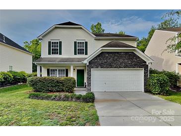 Charming home showcasing a tidy lawn, green door, and a stone-accented two-car garage at 3711 Green Pasture Rd, Charlotte, NC 28269