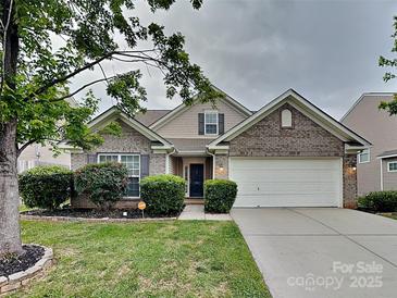 Charming brick home with a two-car garage, manicured lawn, and lush landscaping at 4006 Lawrence Daniel Dr, Matthews, NC 28104