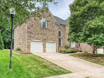 Two-story brick home featuring an attached two-car garage and a well-manicured lawn at 410 Deer Brush Ln, Waxhaw, NC 28173