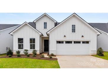 Charming new construction home with a two-car garage, black windows and door, and low maintenance landscaping at 4134 Eastover Glen Rd # 0319, Charlotte, NC 28269