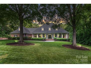 Charming brick home featuring a manicured lawn and mature trees, creating a serene and inviting atmosphere at 4920 Parview S Dr, Charlotte, NC 28226