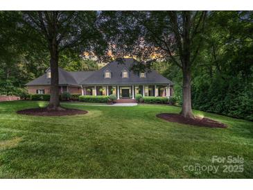 Stately brick home featuring a manicured lawn and mature trees, creating a welcoming curb appeal at 4920 Parview S Dr, Charlotte, NC 28226