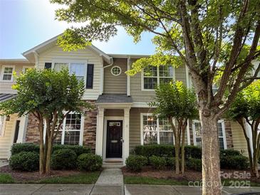 Inviting townhome with a wreath-adorned front door, manicured shrubs, and lovely stone and siding accents at 1139 Drummond Ln, Matthews, NC 28104