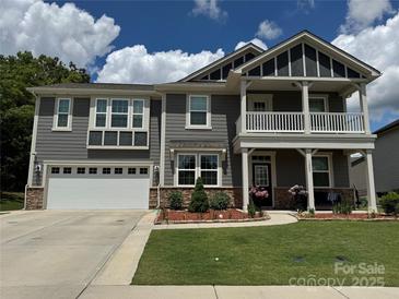 Charming two-story home with a landscaped yard, two-car garage, and inviting front porch at 1205 Aiken Cross Ln, Indian Trail, NC 28079