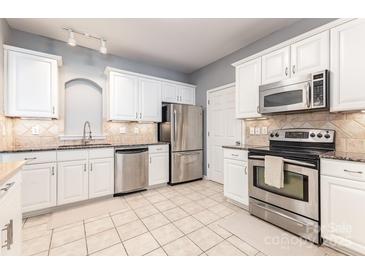 Bright kitchen features stainless steel appliances, ample white cabinetry, and neutral countertops at 14857 Santa Lucia Dr, Charlotte, NC 28277