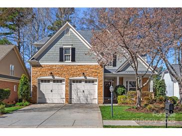 Charming home featuring a stone facade, two-car garage, and lush landscaping in a desirable neighborhood at 19679 Wooden Tee Dr, Davidson, NC 28036