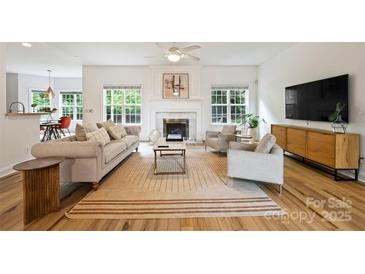 Bright living room with hardwood floors, fireplace, neutral furnishings, and abundant natural light at 20812 Decora Dr, Cornelius, NC 28031