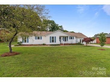 Charming single-story home with a well-manicured lawn, blue shutters, and inviting curb appeal at 2632 Montford Nw Ave, Concord, NC 28027