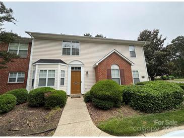 Inviting townhouse showcasing manicured landscaping, siding, brick accents, and a pathway to the front door at 3602 Melrose Cottage Dr, Matthews, NC 28105