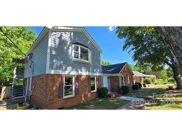 Charming two-story home with a brick facade and gray siding, featuring a well-maintained front yard at 401 Pamela St, Gastonia, NC 28054