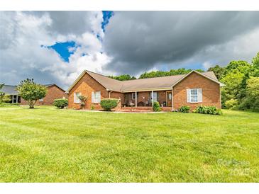 Charming brick home featuring a well-manicured lawn and inviting front porch at 4470 W Bandys Cross Rd, Claremont, NC 28610