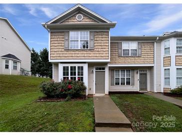 Charming two-story townhome featuring beige siding, a well-maintained lawn, and a welcoming front entrance at 6121 Dane Dr, Dallas, NC 28034