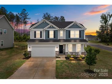 Charming two-story home with a two-car garage, manicured lawn, and beautiful landscaping at 7604 Tanglewood Way, Denver, NC 28037