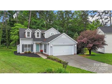 Charming two-story home with a well-manicured lawn, an attached garage, and tasteful landscaping at 8302 Holbrook Square Ct, Charlotte, NC 28216
